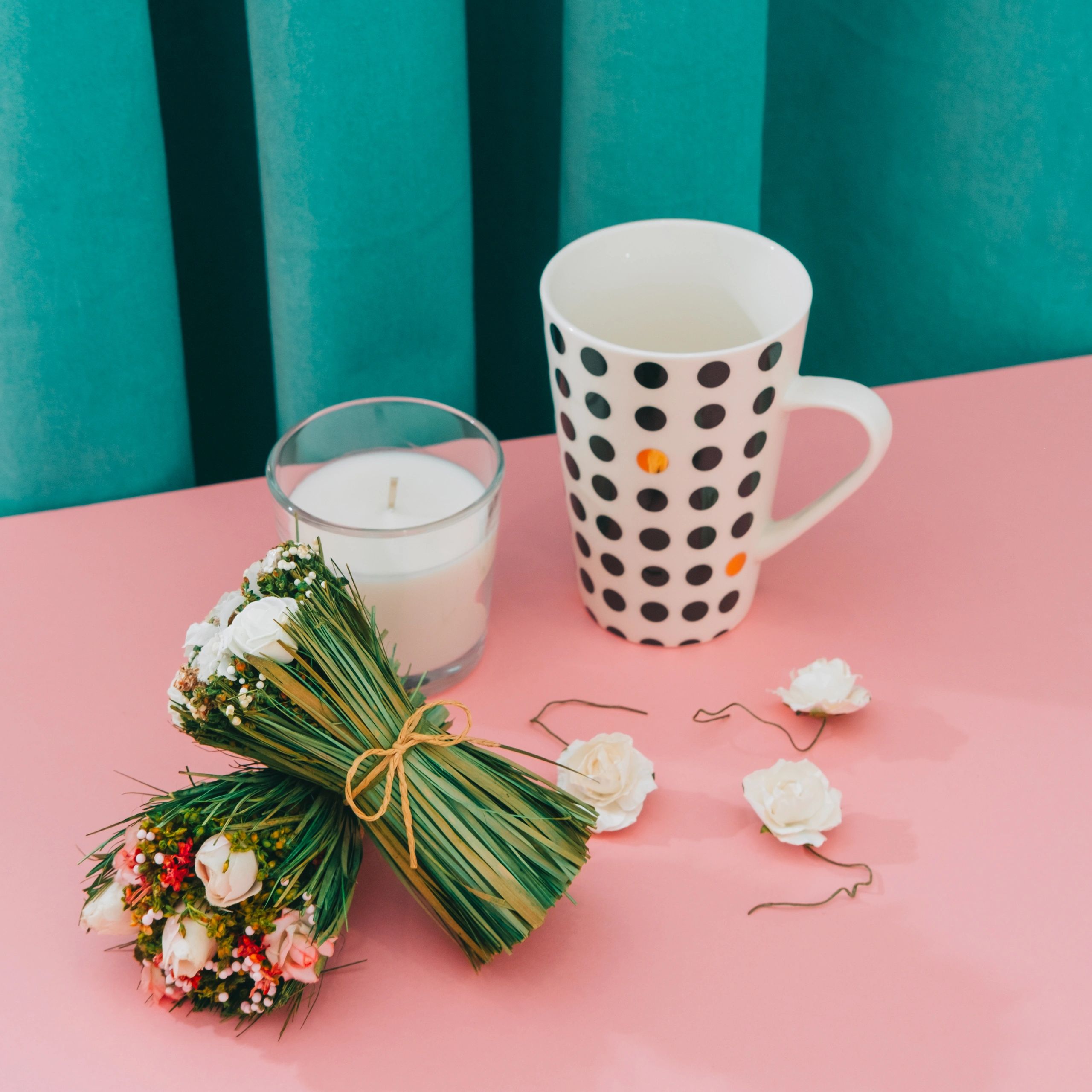 Pastel floral still life with roses, candle, and mug