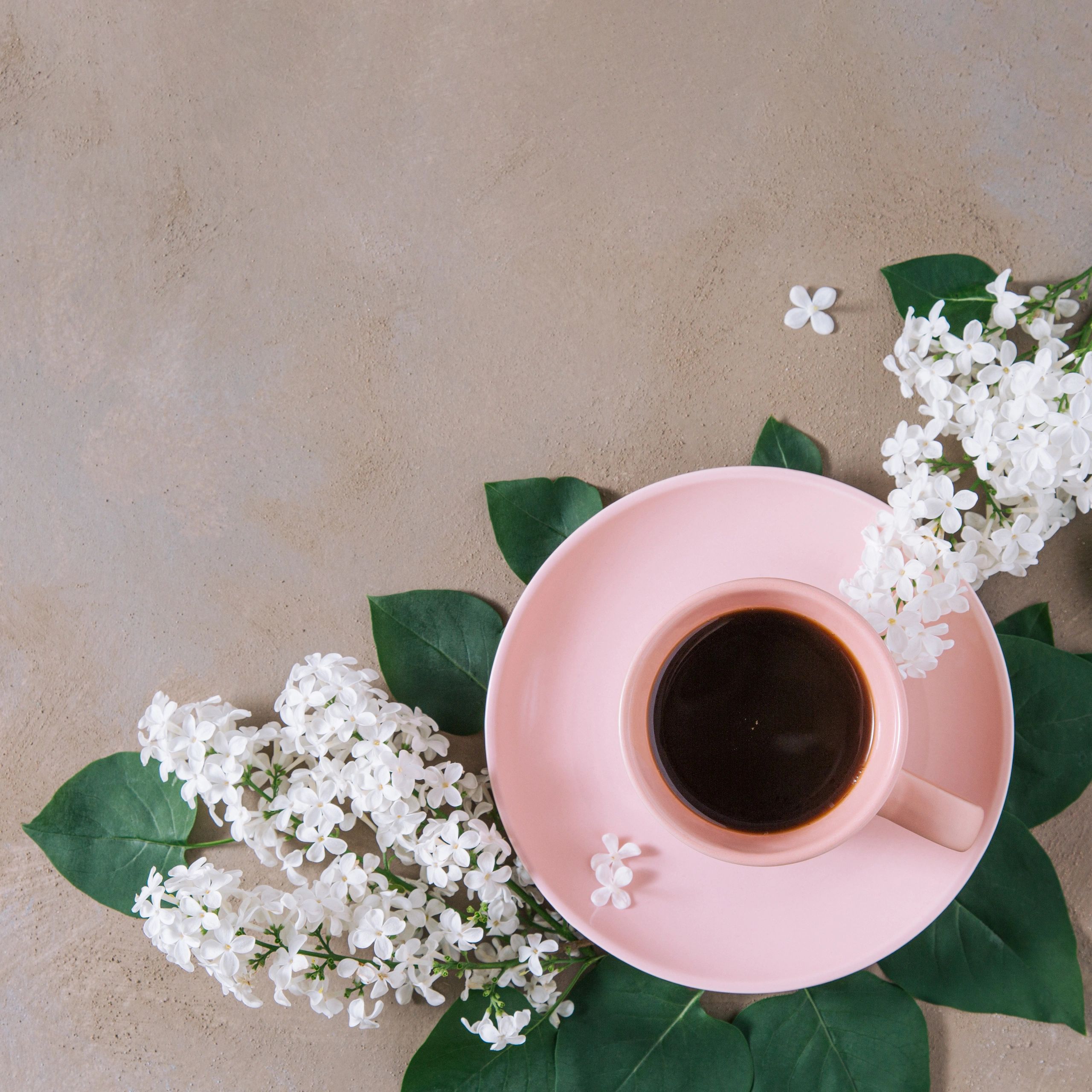 Coffee cup with flowers and leaves in a pastel still life